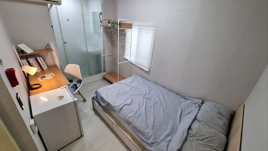 천안 고시원 규스테이 샤워실 유리문과 창, 침대가 보이는 디럭스룸